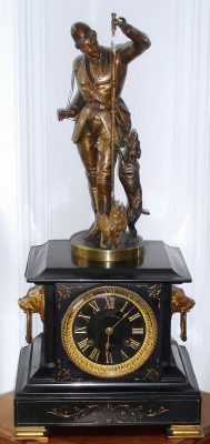 C.1885, French, Guilmet, HUNTSMAN, mystery clock, the patent crank and stirrup movement contained in the base flanked by two bronze dogs heads, the statue of a huntsman with rifle [on his back] and dog at his side, and the pendulum a dead pheasant. The pendulum swings with no apparent impulse from the movement, however the entire statue swivels slightly on its pivoted base to lock and unlock the escapement. — Antique Clocks Price Guide