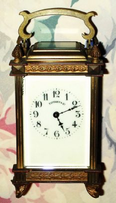 C.1900, French for Tiffany, Carriage Timepiece, in an unusual brass case with reeded columns, cast French feet, pineapple finials and bands of acanthus leaves around top and bottom. — Antique Clocks Price Guide
