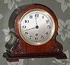 C.1922, Waltham Clock Co., Model 1155, in a balloon style case with carved accents, with Waltham No. 12 time only lever movement, with platform spanning the plates at top. 