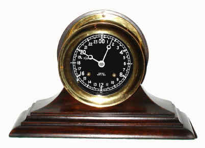 C.1985, Chelsea Clock Co., "The Chelsea" , with 4.5" 24 hour black dial / white hands and numerals, eight-day Ship's Bell on original mahogany stand, serial 857476, screw bezel — Antique Clocks Price Guide