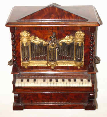 C.1860, Swiss or Austrian, Musical Jewel box in the form of an organ, two drawers locked behind the rank of silvered brass pipes attached to the front doors. Music is actuated by simply pressing the keyboard, when it plays one of 2 tunes and stops; key-wound from the rear. — Antique Clocks Price Guide