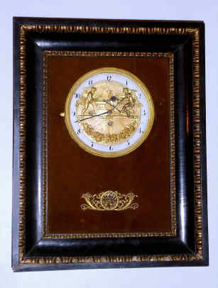 C.1820, Austrian, Grand Sonnerie automaton picture frame clock, 2 cherubs, the one at right sharpens his arrow at the wheel on the qtr hour and the one at left swings his hammer against the anvil on the hour, silk suspension, 2 day duration. — Antique Clocks Price Guide