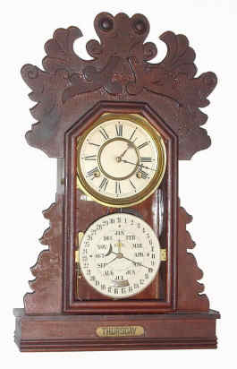 C.1894, Charles W. Feishtinger, Fritztown, Penn., 8-day time/strike double dial calendar gingerbread clock, day of week showing in base. Cases and movements were made by the Waterbury Clock Co., and later entirely made by Waterbury for Feishtinger. This example is the "Hardin" model. — Antique Clocks Price Guide
