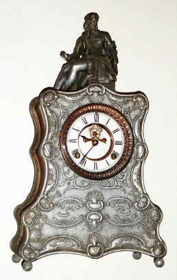 C.1893, Waterbury Clock Co., NAVARRO, cast figural mantel clock with copper sides, silver finish, open escapement on the dial. A popular name of Spanish heritage, Navarro is also a small town in Texas. — Antique Clocks Price Guide