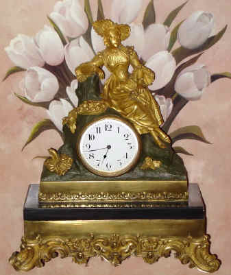 C.1900, French, Ormolu and Marble, figural clock, the Fruit Lady, in Victorian dress and hat, attending a basket of fruit and blossoms, with a bouquet in her left hand, time only movement, 8-day, rear wind and set. — Antique Clocks Price Guide