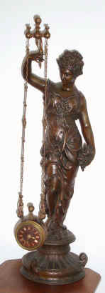 C.1880, French, Uncommon Mystery Timepiece, the clock contained in a drum suspended from two parallel chains, held aloft by a female statue. — Antique Clocks Price Guide