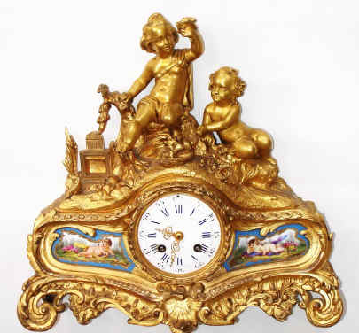 C.1875, French, Ormolu Figural clock, PLAYING CHILDREN, showing a young boy and girl in the woods with a bird nest, holding one chick aloft and with an open bird cage to one side, ready to receive the new pet. — Antique Clocks Price Guide