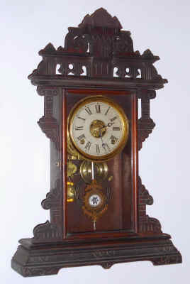 C.1885, E. N. Welch Mfg. Co., ECLIPSE, walnut parlor clock with fancy cast pendulum with sandwich glass center. — Antique Clocks Price Guide