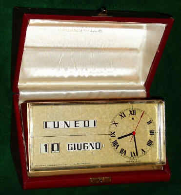 C.1980, Swiss/Italian, Robert Dessomville, calendar desk clock, 1.5v battery power, the clock made in Switzerland, the perpetual calendar and case made in Italy [plastic gears], in a silk lined and leather covered presentation box, the top of the clock engraved "Con un arrivederci in Italia", and with the months and days of the week showing in Italian. — Antique Clocks Price Guide