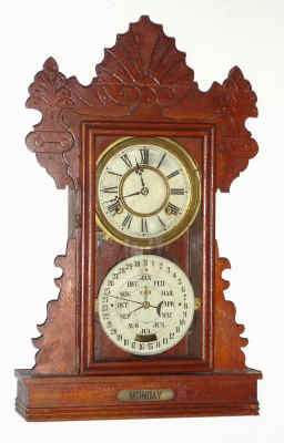 C.1894, Charles W. Feishtinger, Fritztown, Penn., 8-day time/strike double dial calendar gingerbread clock. Cases and movements were made by the Waterbury Clock Co., and later entirely made by Waterbury for Feishtinger. This example is the "Hendon" model. — Antique Clocks Price Guide