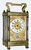C.1900, French, Brass Cased Carriage Clock, time and alarm, in an unusual hexagonal case with 6 vertical columns and 7 total panes of beveled glass, with a gilt floral dial mask with porcelain chapter and alarm rings.