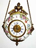 C.1900, French, CARTEL timepiece, round donut shaped porcelain case with cast metal trimmings, and with a round 8-day pivoted pendulum movement.