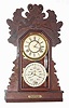 C.1894, Charles W. Feishtinger, Fritztown, Penn., 8-day time/strike double dial calendar gingerbread clock, day of week showing in base. Cases and movements were made by the Waterbury Clock Co., and later entirely made by Waterbury for Feishtinger. This example is the "Hardin" model.