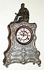 C.1893, Waterbury Clock Co., NAVARRO, cast figural mantel clock with copper sides, silver finish, open escapement on the dial. A popular name of Spanish heritage, Navarro is also a small town in Texas.