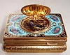Late 20th Century, German/Swiss, singing bird box with enameled scene on the cover of a gentleman presenting a gift to a lady in pastoral setting, the surround in aqua colored enamel accented with yellow and pink roses.