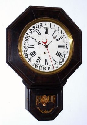 E. Ingraham and Co., short drop octagon timepiece, poplar case with dark finish, 8-day with simple calendar. C. 1910. — Antique Clocks Price Guide