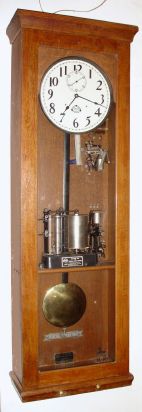 Landis Programmable Clock Co., Waynesboro, PA (1910-1937), oak cased electric master clock with central programmable mechanism intact. Landis bought out Fred Frick around 1910. The movement is to Frick's design, an iron A frame with brass bushings; see "150 Years of Electric Horology", page 29 for further details. C.1920. — Antique Clocks Price Guide