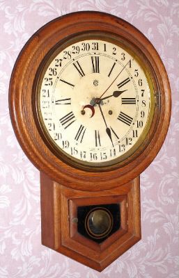 Waterbury Clock Co, "12-Inch Round Head Drop" with concentric calendar. oak cased, 8-day time and strike. C.1900. — Antique Clocks Price Guide