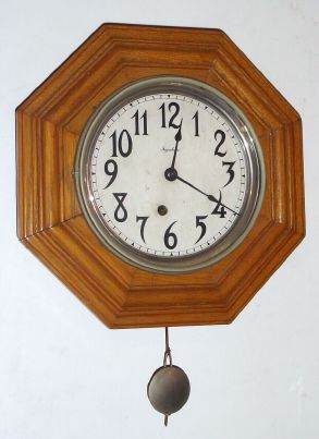 E. Ingraham and Co., 8-day, oak octagon wall timepiece, pendulum movement. Circa 1915. — Antique Clocks Price Guide