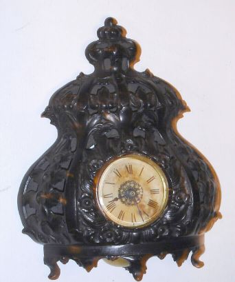American cast and pierced iron cased alarm clock, under a round glass dome w/ base from the same period. C.1900. — Antique Clocks Price Guide