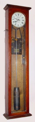 English, SYNCHRONOME, for Dykes Bros, Glasgow, Scotland, heavy iron framed electro mechanical movement that proved to be the standard of the industry from 1905 through 1955, in an oak case with side locks. C.1925 — Antique Clocks Price Guide