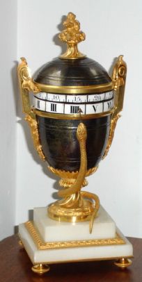 French, Urn shaped annular dial timepiece, with brightly gilded serpent and accents against a brass urn and lid, the dials with individual porcelain numerals, Roman for hours and Arabic for minutes, C.1890 — Antique Clocks Price Guide