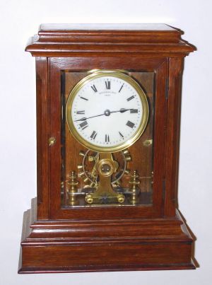 English, EUREKA battery powered mantel clock serial No. 7085, in an oak case, the front door glazed with beveled glass and revealing the large balance wheel, C.1915 — Antique Clocks Price Guide