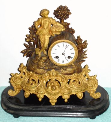 German, Lenzkirch, Cast /gilt mantel clock of a young farmer In Sunday clothes + his basket of roses, 8-day bell strike, serial No. 263496, with a period dome and base. C.1863 — Antique Clocks Price Guide