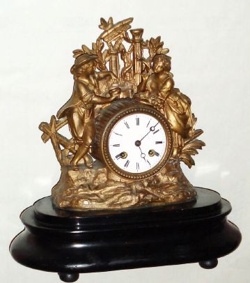 French, S. Marti et Cie, cast spelter figural mantel clock, with patinated gold appearing finish, showing a boy offering a nest of eggs to a girl with a basket of roses, 8-day, bell strike, mounted to a wooden base (no dome) C.1900 — Antique Clocks Price Guide