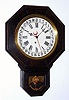 E. Ingraham and Co., short drop octagon timepiece, poplar case with dark finish, 8-day with simple calendar. C. 1910.