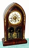 Waterbury Clock Co., "CORINTH GILT", rosewood mantel clock with gilt accents, 8-day time and gong strike, with bell alarm, spring C.1885