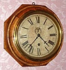 Waterbury Clock Co., "8 INCH LEVER", octagonal wall timepiece in a segmented and turned oak case, 8-day, spring. C.1890.