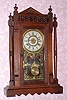 New Haven Clock Co., "VISTULA" walnut cased parlor clock with lots of turned trim and finials, 8-day, time, cathedral gong strike (heavy flat wire) and bell alarm. C.1885.