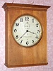 American Clock Company, Chicago Ill, electric time mvt in rectangular birch case, 13" dial with second's bit under 12 o'clock, designed to be electrically driven by two No. 6 dry cell batteries. C. 1920.