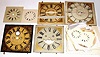 Box lot including a large assortment of modern paper dials and eight antique wooden dials in various states.