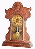 E. Ingraham and Co., "242", 8-day time/strike/alarm oak mantel clock, commemorative series with winged cherubs at work, top left with hammer, anvil and vice, bottom sections w/ cherubs turning a handle on some fanciful contraption, and with an Army/Navy base molding with stars and anchors. Pressed oak case retains its original crazed finish. This was a special order case produced for a customer as indicated on the partial label on the whose name we cannot read. Original paper dial has age darkened. Hands, pendulum and tablet are original. Circa 1905.