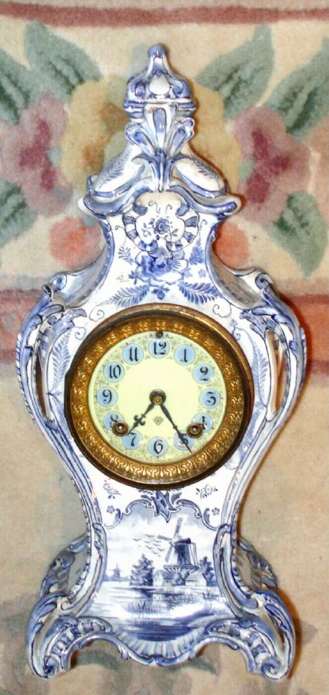 Ansonia Clock Co., C.1895, Royal Bonn, "LA ROCHELLE", decorated in Blue Delft style, and signed on rear "Royal Bonn/Delft", with smaller 8-day Ansonia movement and with fancy cream dial with numerals on blue background. — Antique Clocks Price Guide