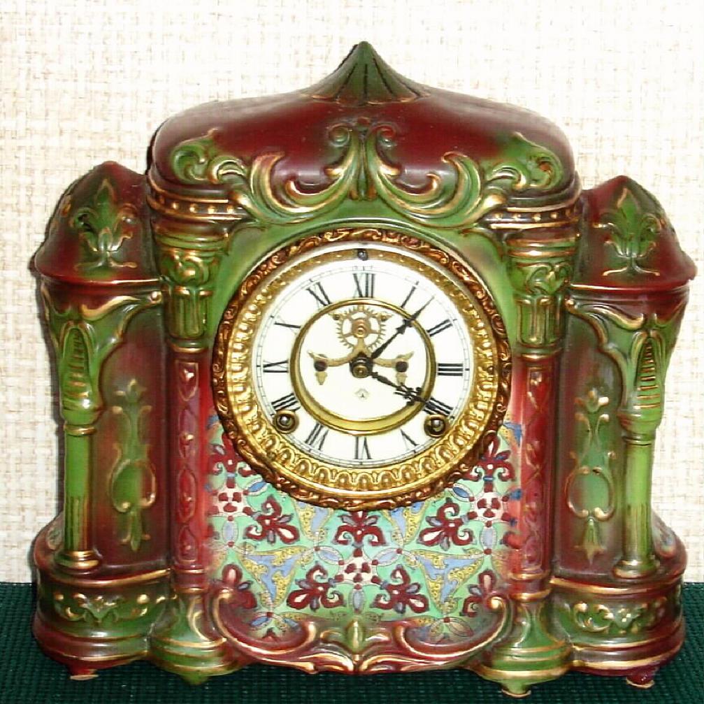 Ansonia Clock Co., C.1902, "DELTA" porcelain china cased clock, with 8-day, gong strike mov't with open escapement on porcelain dial. Colors are rust and green with fancy painted pattern below dial. — Antique Clocks Price Guide