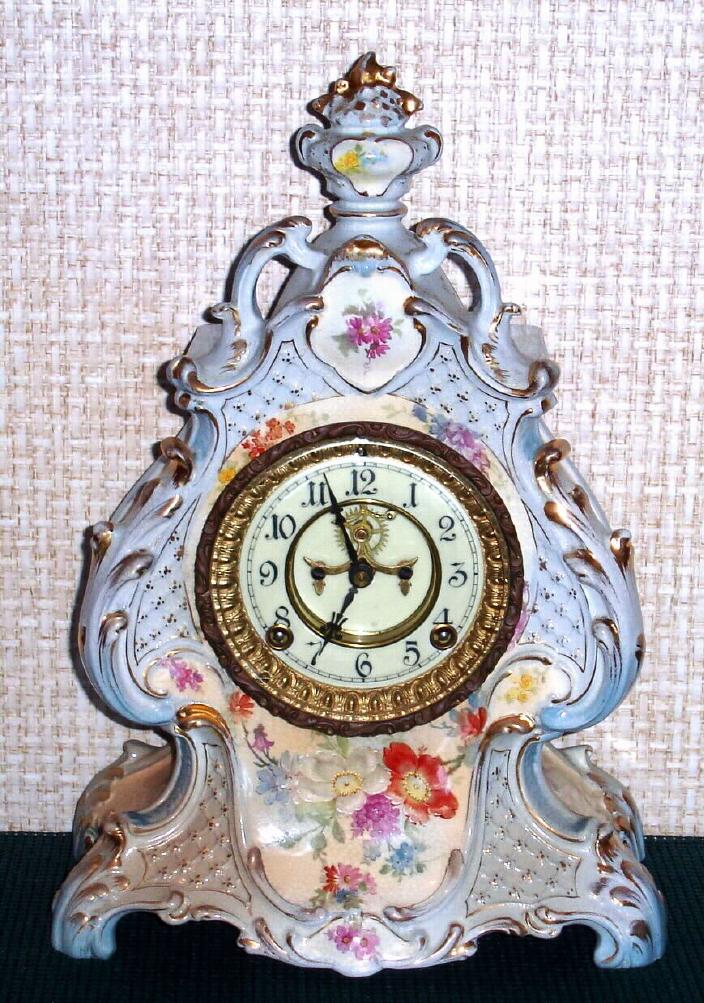 Ansonia Clock Co., C.1910, Royal Bonn, "LA LOIRE" porcelain china cased clock, with 8-day, gong strike mov't with open escapement on porcelain dial, in a creamy case with light blue accent and gold highlights. — Antique Clocks Price Guide