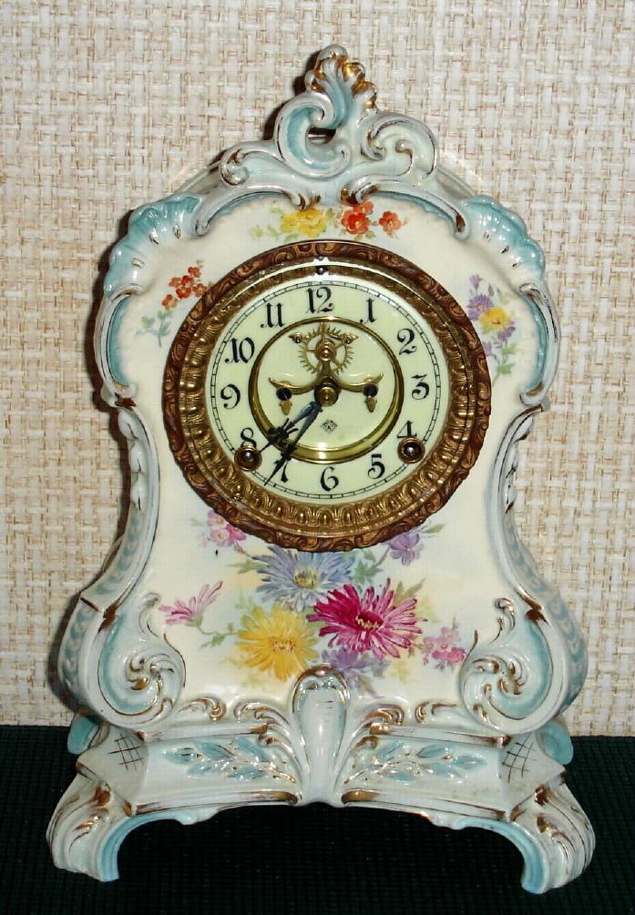 Ansonia Clock Co., C.1895, Royal Bonn, "LA CALLE" porcelain china cased clock, with 8-day, gong strike mov't with open escapement on porcelain dial, in white case with light blue accents and gold highlights. — Antique Clocks Price Guide
