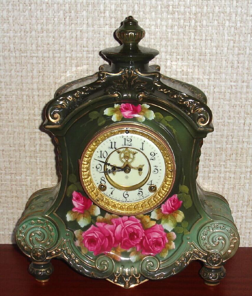 Ansonia Clock Co., C.1914, Royal Bonn, "LA FLANDRE" porcelain china cased clock, with 8-day, gong strike mov't with open escapement on porcelain dial, in a very dark muted green case with red roses. — Antique Clocks Price Guide