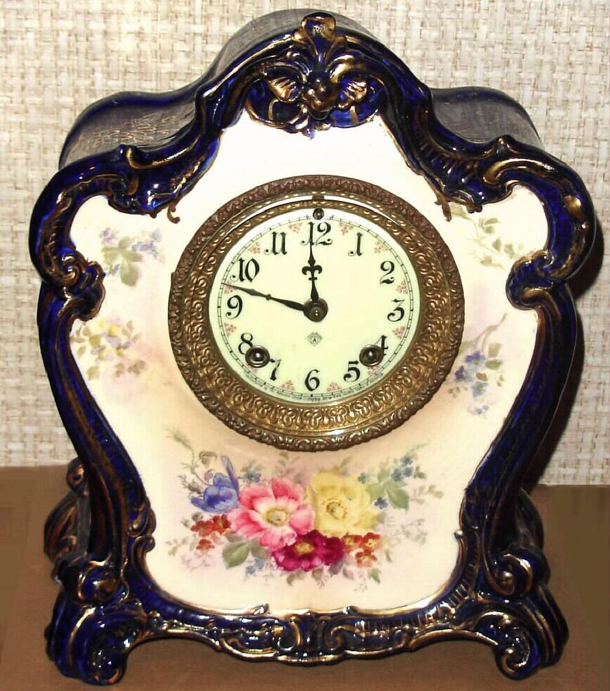 Ansonia Clock Co., C.1905, Royal Bonn, "LA MURE" porcelain china cased clock, with 8-day, gong strike mov't with one piece porcelain dial, the case in dark cobalt blue with gold highlights and floral decorations. — Antique Clocks Price Guide