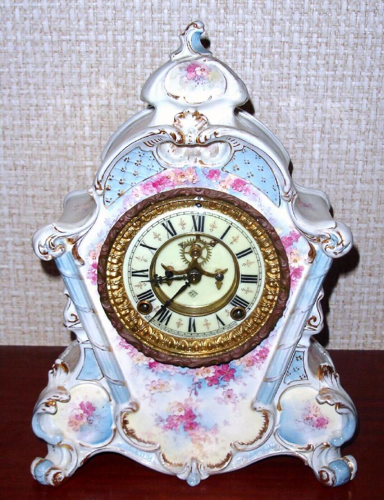 Ansonia Clock Co., C.1895, Royal Bonn, "No. 502" porcelain china cased clock, with 8-day, gong strike mov't with open escapement on porcelain dial, in a creamy case with light blue accents and small dark pink flowers. — Antique Clocks Price Guide