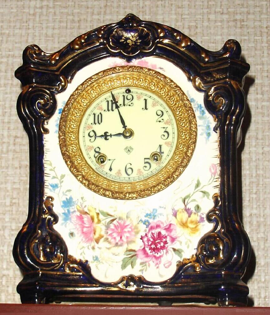 Ansonia Clock Co., C.1905, Royal Bonn, "LA GARD" porcelain china cased clock in cobalt blue, with 8-day, gong strike mov't with one piece creamy porcelain dial with fancy red trim between the numerals. — Antique Clocks Price Guide