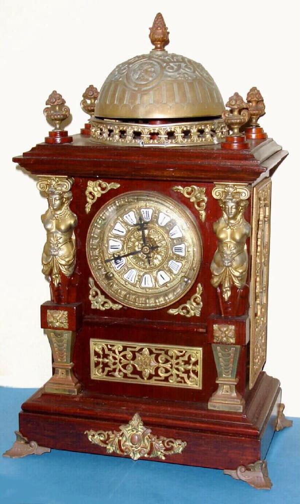 Ansonia Clock Co., "CABINET ANTIQUE, No. 1", sometimes called the bell top antique, in oak with brass plated metal trimmings, this clock with fancy brass dial with individual porcelain cartouche numerals, c.1894 — Antique Clocks Price Guide
