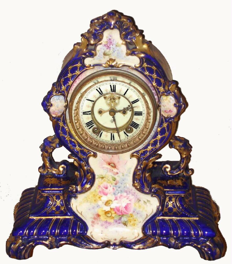 Ansonia Clock Co., C.1910, Royal Bonn, "LA CERDA" porcelain china cased clock, Cobalt Blue, with 8-day, gong strike mov't with open escapement on porcelain dial, with a hand painted blossoms in pastel colors, the entire case with profuse gold highlights. Bonn trademark on rear in gold. — Antique Clocks Price Guide