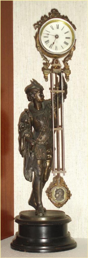 Ansonia Clock Co. New York, C.1896, "FISHER" canister swing clock (3" dial), on deep iron base. Note cast figure hold the clock arm aloft, and the entire arm swings without apparent impulse. — Antique Clocks Price Guide