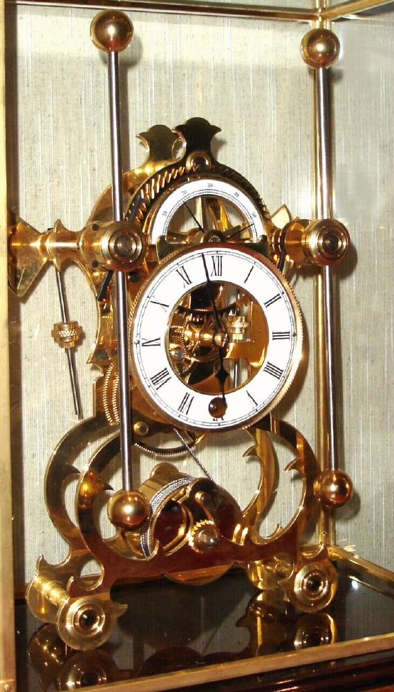 Chinese, Skeleton clock, after the style of Harrison, with a grass hopper escapement, single fusee timepiece, in a glazed case w/ brass edges, front door for winding, and a drawer in the base to hold the key. — Antique Clocks Price Guide