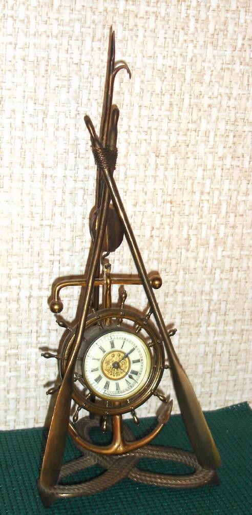 Ansonia Clock Co. New York, C.1900, "NAVY", 1-day novelty clock, consisting of a clock in an anchor, hung from block and tackle, suspended from the top of tow oars and a grappling hook, the whole with a trefoil of rope as a base. — Antique Clocks Price Guide