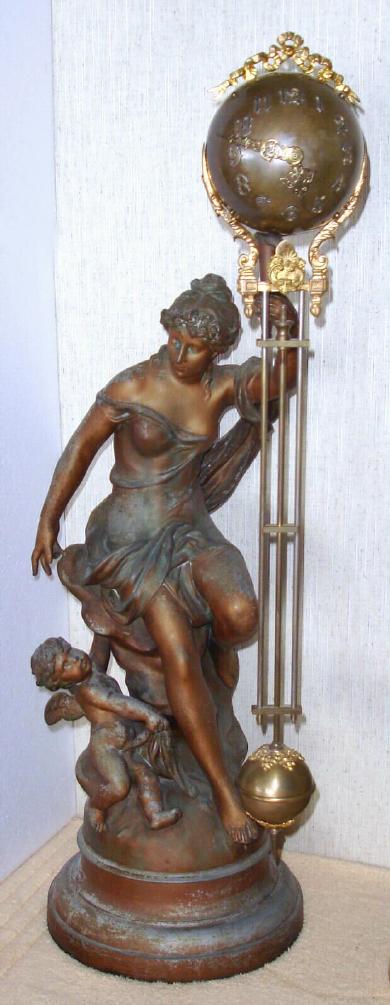 Ansonia Clock Co. New York, C.1906, "FORTUNA", swinging arm timepiece, 8-day, the movement contained within the ball at top, the entire arm swinging without apparent impulse. The Goddess Fortuna is setting with a cherub playing at her side. Utilizes long arm 25.5" in length. — Antique Clocks Price Guide